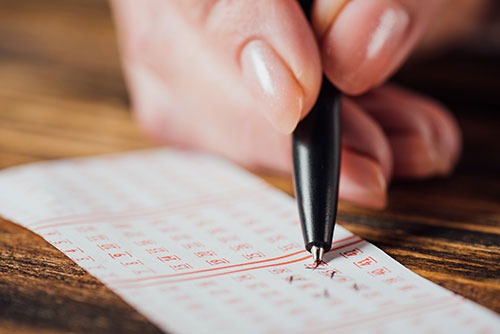 Person Filling In Lottery Ticket